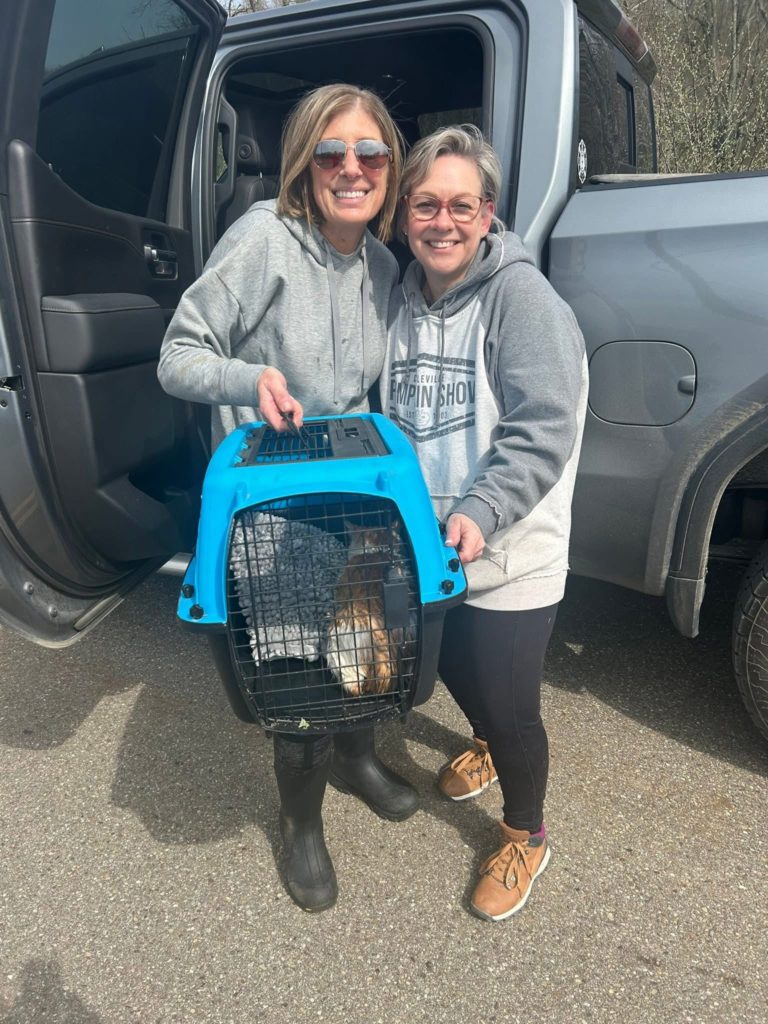 2 women and a cat in carrier