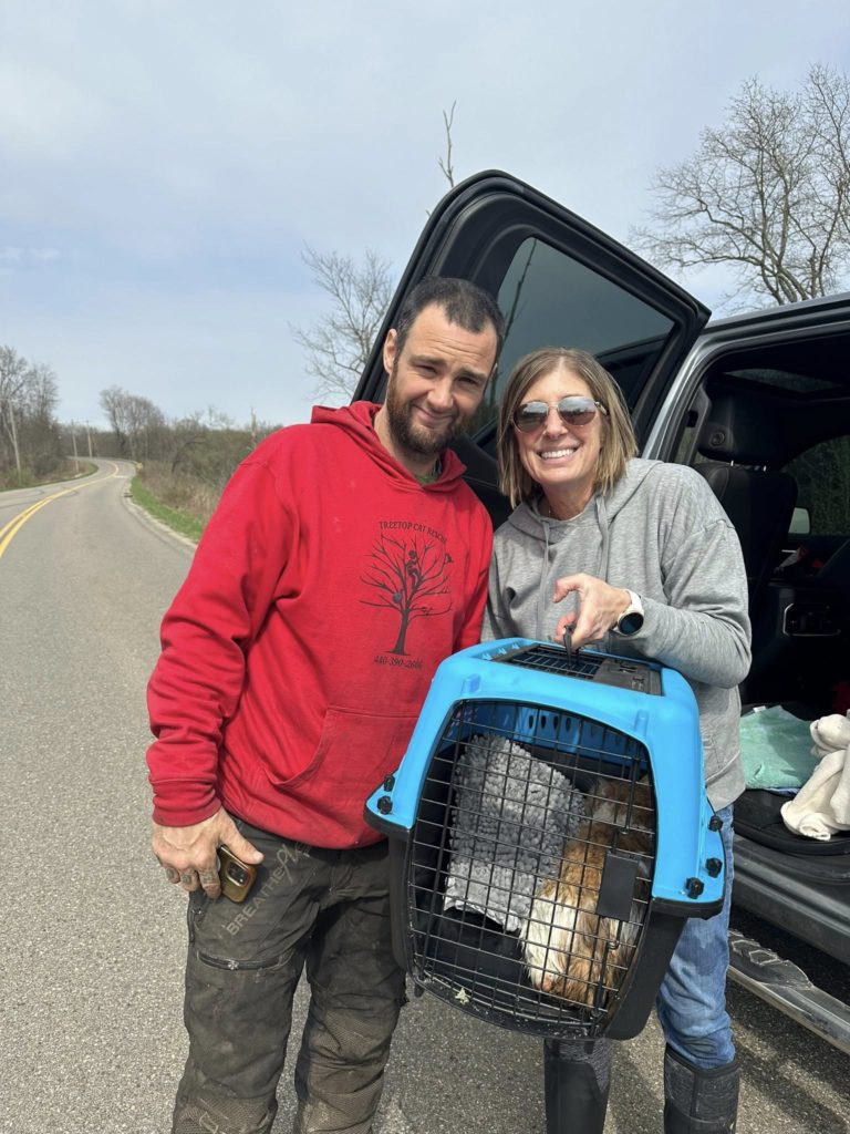 Two people with cat in carrier